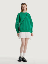 A lady wears a green sweatshirt.